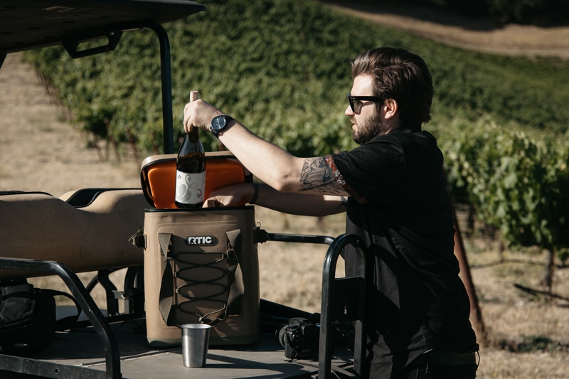 model grabbing beverage from RTIC backpack cooler